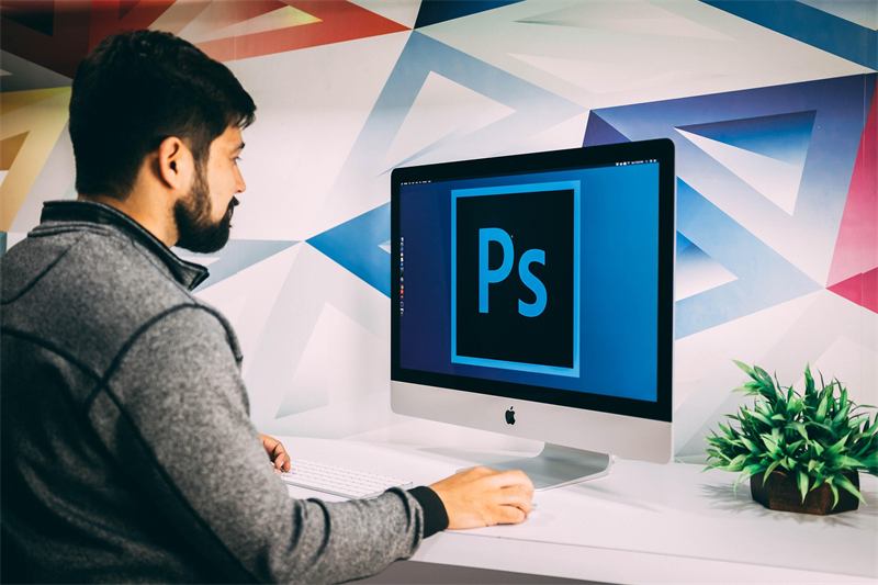 Designer working in Photoshop at a desktop computer