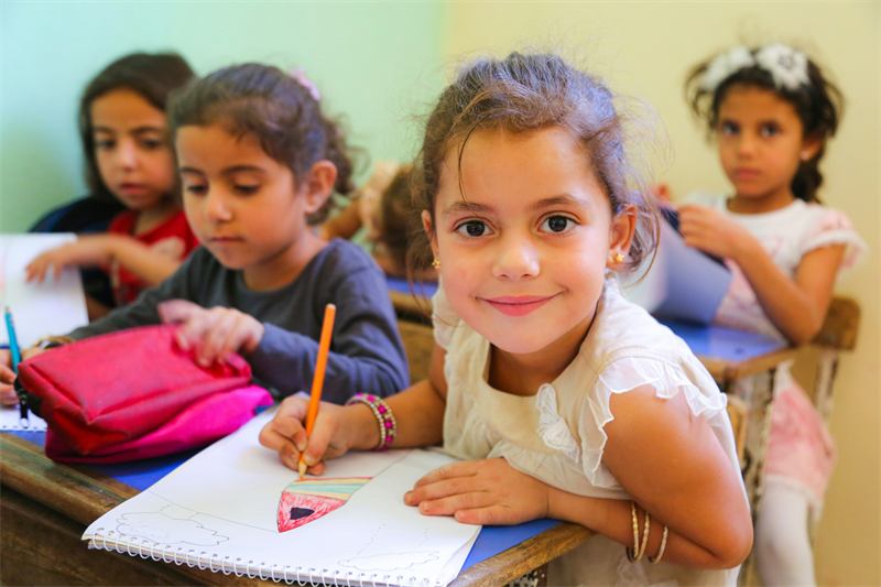 Smiling girl drawing in class