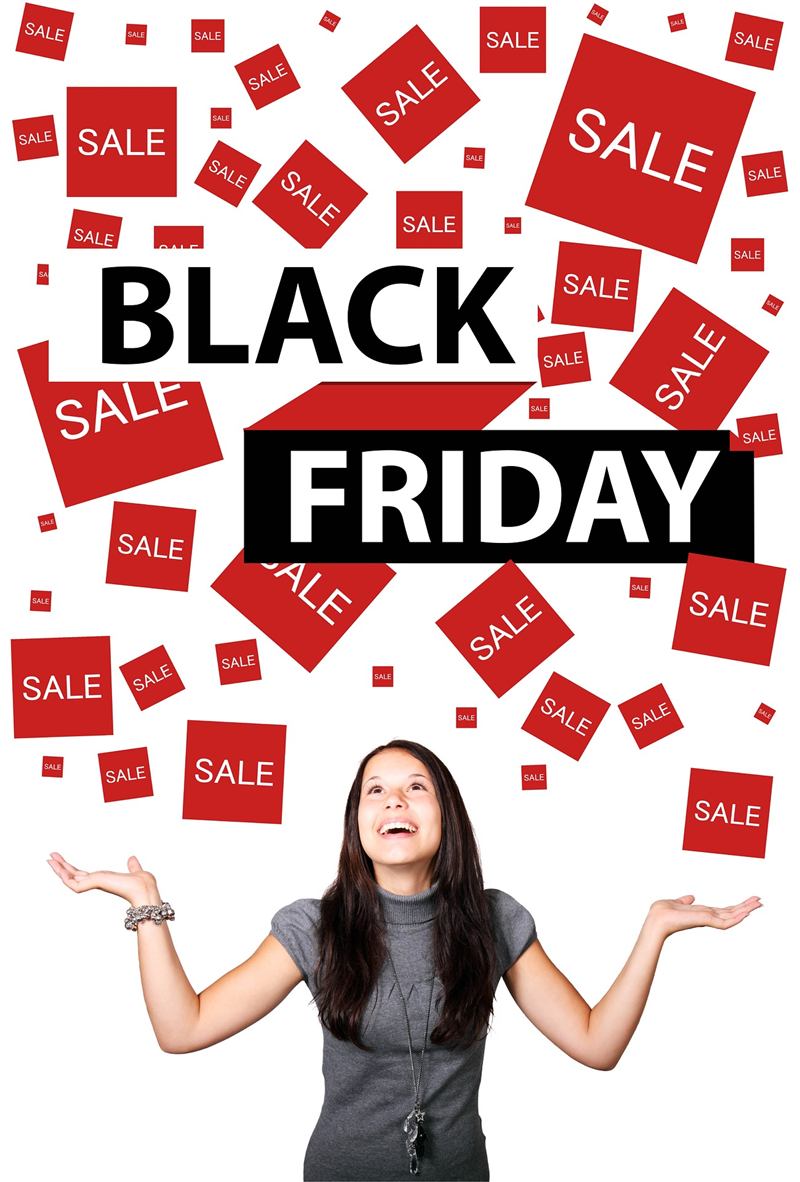 Shopper under Black Friday sale signs