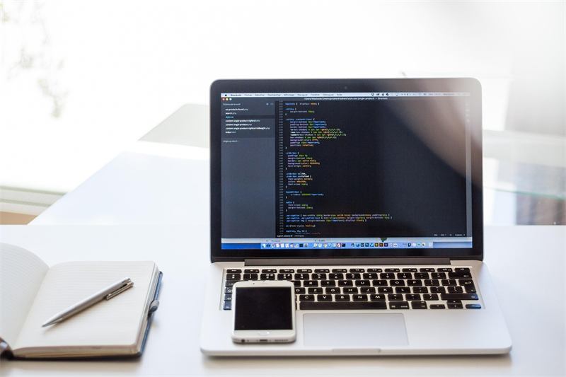 Laptop showing source code on a bright desk