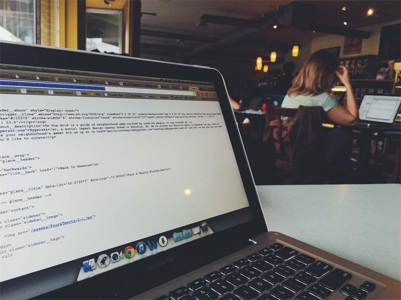Laptop with website code open in a café